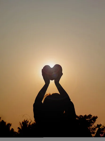 Silhouet achterkant van vrouwen verhogen haert naar hemel in schemering — Stockfoto