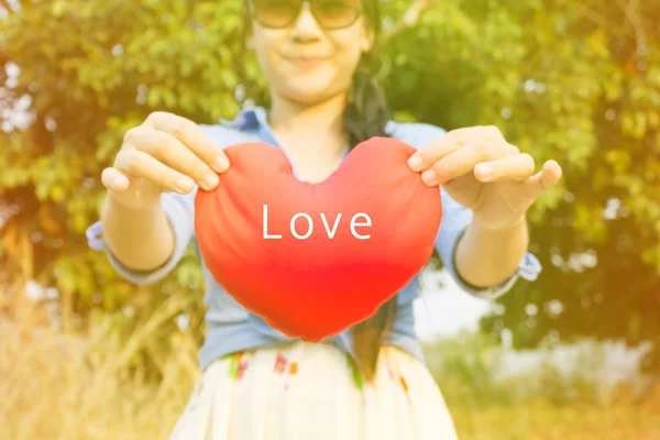 Vrouwen hand zachtjes houd rood hart met tekst liefde — Stockfoto