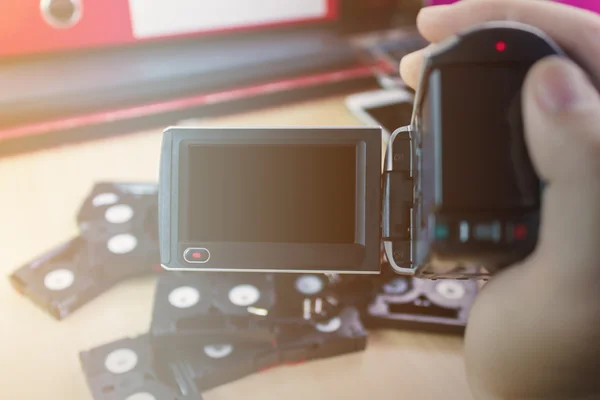 Gravação de fitas cassete de câmera de mão e vídeo no backgro do escritório — Fotografia de Stock