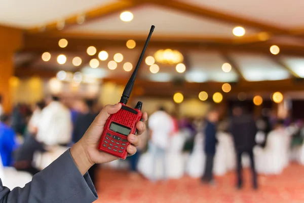 Красное радио в руке с фоном зала — стоковое фото