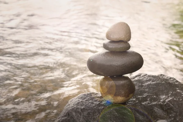 Superimposed waterfall pebble rock arranged on big stone — Stock Photo, Image