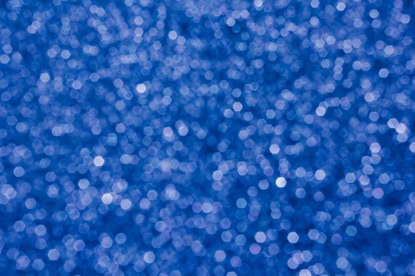 Mavi arka plan üzerinde parlayan küçük bokeh ışık ışıltı — Stok fotoğraf