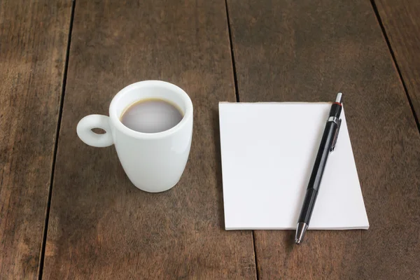 Witte kop kleine warme zwarte koffie met lege Opmerking boek en pen Stockfoto