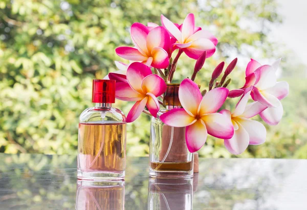 Flasche süßen rosa duftenden Parfüms mit rosa Blume plumeria — Stockfoto