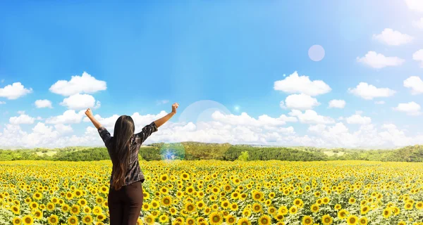 Rara vista delle donne alzare braccia abbracciano campo di girasoli con natu — Foto Stock
