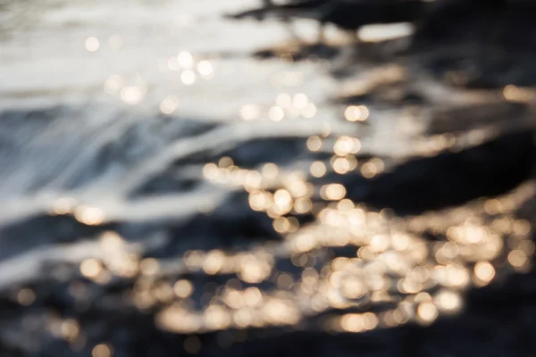 Bokeh macio dourado e laranja da superfície da água e da luz solar para — Fotografia de Stock