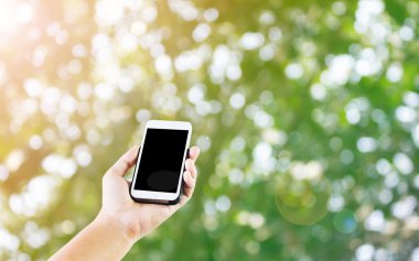 Lady el sunan veya doğa bokeh ağaç b cep telefonu göstermek