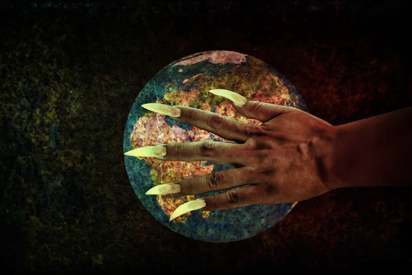 人的手与长指甲或魔鬼的手在生锈的地球普拉 — 图库照片