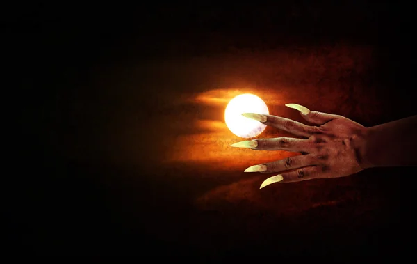 Mão humana com unhas longas ou mão do diabo na noite de lua cheia — Fotografia de Stock