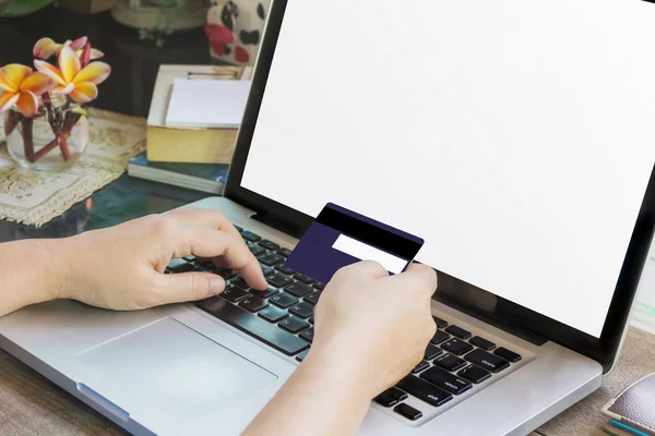 Women hands hold credit or debit card (ATM) and notebook or laptop — Stock Photo, Image