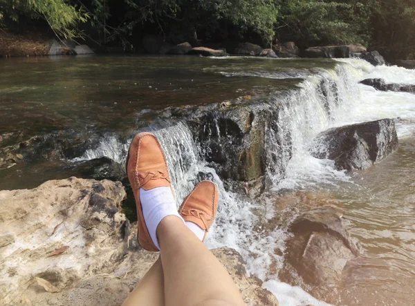 Legs from sit view and looking waterfall — Stock Photo, Image