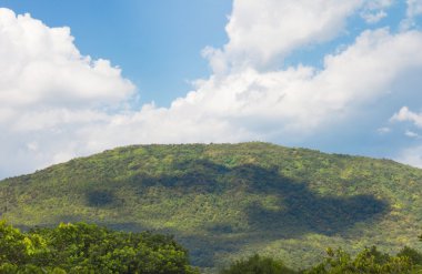 bulutlu gökyüzü ile dağ manzarasıüzerinde yeşil orman 
