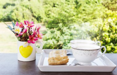 Çift fincan sıcak kahve pasta ve çiçekler doğa görünümü ile