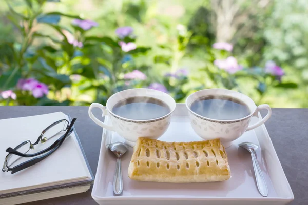 Deux tasses de café noir chaud avec tarte sur plaque blanche décorée w — Photo