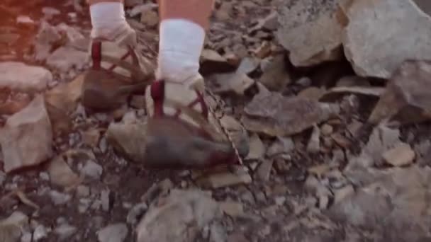 Primer plano de los pies del excursionista caminando en la montaña rocosa — Vídeo de stock