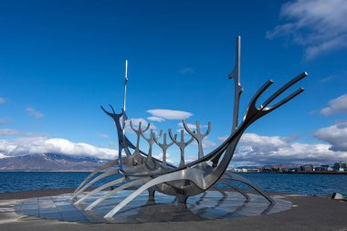 REYKJAVIK, ICELAND - 11 Haziran 2021: The Sun Voyager, Jon Gunnar Arnarson tarafından Reykjavik rıhtımında yapılmış ve Viking uzun gemisine benzeyen çelik bir heykel. Güneşli gün, mavi gökyüzü. 