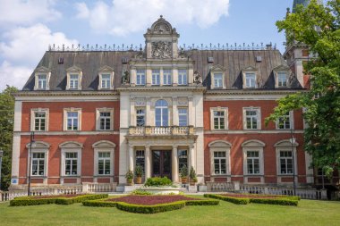 PAWLOWICE, LOWER SILESIA /POLAND - June 16, 2021: A XIX century, eclectic palace with elements of baroque and renaissance revival. A Palace is surrounded by a lovely park. Sunny, summer day, blue sky. 