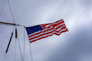 REYKJAVIK, ICELAND - June 11, 2021:A national flag of United States of America, fluttering in the wind, on mast of an American coastguard tallship Eagle, visiting Reykjavik Harbour. 