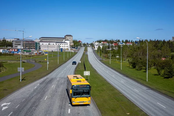 REYKJAVIK, ICELAND - 12 Haziran 2021: Njardargata üst geçidinden Hringbraut yoluna bir görüntü. Nadir araba trafiği ve sarı bir şehir otobüsü. 