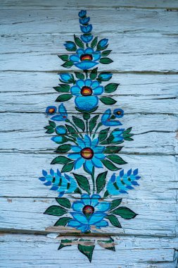 ZALİPİ, POLAND - 1 Ağustos 2021: Beyaz ahşap bir duvara boyanmış geleneksel, renkli bir çiçek deseni. 