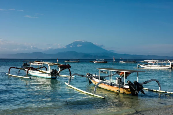 Nusa Lembongan sahilinden Gunung Agung volkanı, Bali, Endonezya 'ya güzel bir deniz manzarası. Geleneksel Endonezya jukung outrigger kano trimaran tekneleri önde.. 