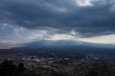Fuji Dağı 'nın karla kaplı tepesinde, bulutlarla çevrili. Görüntü Fujikawaguchiko, Japonya.