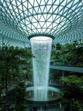 Singapur Şehri, Singapur - 29 Şubat 2025: Yağmur Girdabı, dünyanın en yüksek kapalı şelalesi, Jewel Changi Havaalanı 1 terminali içinde tropikal bitkilerle çevrili..