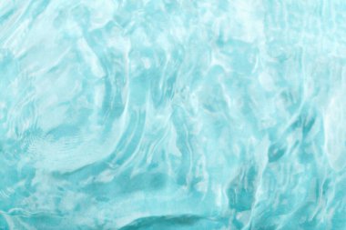 Su altyapısı. Temiz turkuaz su yüzeyi yumuşak dalgalar ve yansımalar göstererek sakin bir ortam yaratır. Işık suda dans eder, dinginliği arttırır ve görsel deneyimi tazeler.