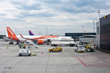 Ivan Paul Havaalanı, Krakow, Polonya - 07 Mayıs 2025: EasyJet uçağı havaalanı terminaline park edilmiş, yer ekibi kalkışa hazırlanıyor, modern hava araçlarıyla yoğun havacılık sahnesi sergileniyor