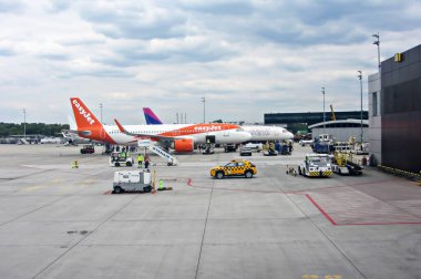 İvan Paul Havaalanı, Krakow, Polonya - 07 Mayıs 2025: Havalimanı terminaline park etmiş, yer ekibi ve araçlar kalkışa hazırlanıyor, yoğun havacılık ortamı sergileniyor