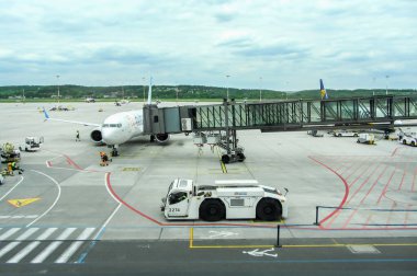 Ivan Paul Havaalanı, Krakow, Polonya - 07 Mayıs 2025: Jet köprüsü bağlı havaalanı kapısındaki uçak, yer ekibi yolcu alımı, havacılık operasyonları ve seyahat lojistiği için hazırlanıyor