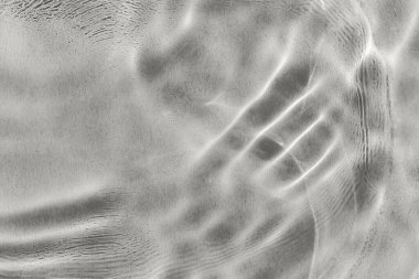 Siyah ve beyaz desenli su yüzeyine sahip soyut görüntü, dalgalanmalar gösteriyor. Işık ve gölgenin etkileşimi dinamik görsel efekt yaratır. 2026 yılının gösterişli rengi, Bulut, Dansçı