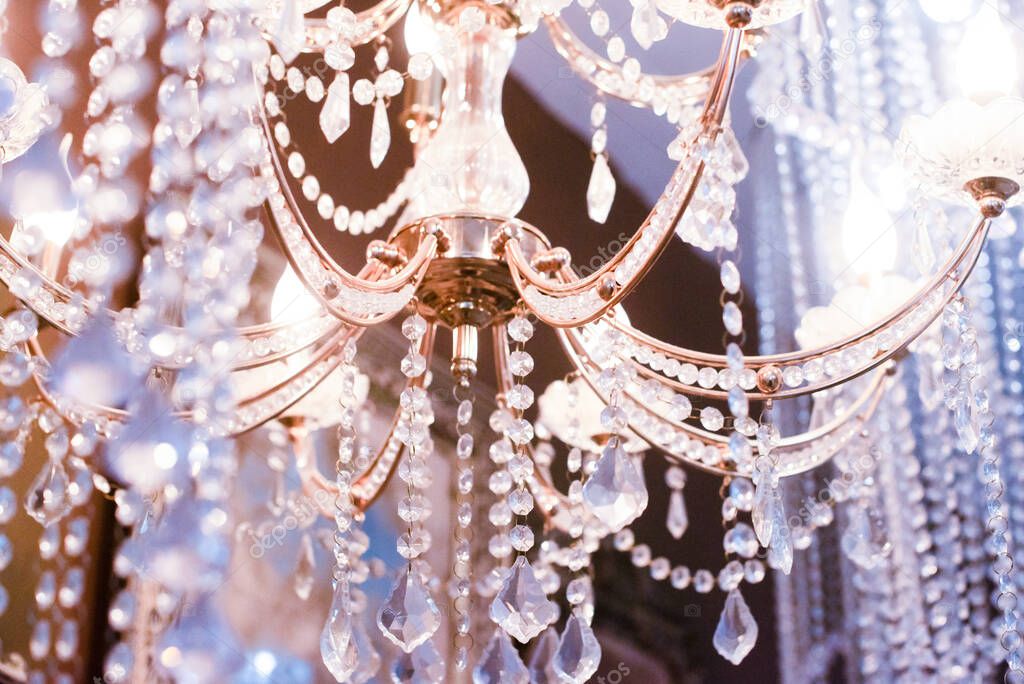 Crystal chandelier close-up. pink, purple, silver light Selective focus