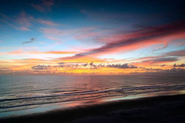 Bu Daytona Sahili, FL 'de denizin üzerinde güzel bir gün doğumu. Sahilde güneşin doğuşunu tüm ihtişamıyla seyreden birkaç kişiyle sevişebilirsin..