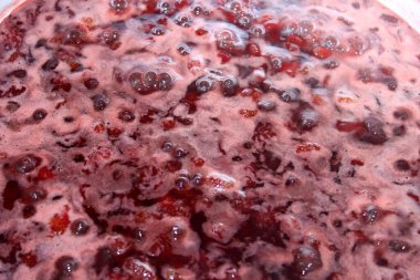 Bir tencerede kaynamış çilek reçeli. 