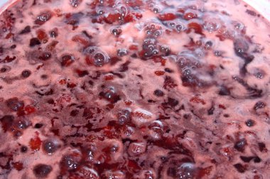 Bir tencerede kaynamış çilek reçeli. 