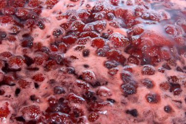 Bir tencerede kaynamış çilek reçeli. 