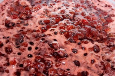 Bir tencerede kaynamış çilek reçeli. 