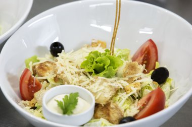 Tavuk ve yeşillikleri, cherry domates, marul ahşap masa üzerine Sezar salatası.