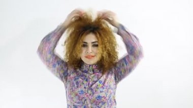 Onun kıvırcık kırmızı (zencefil) beyaz arka plan ile oynayan kadın