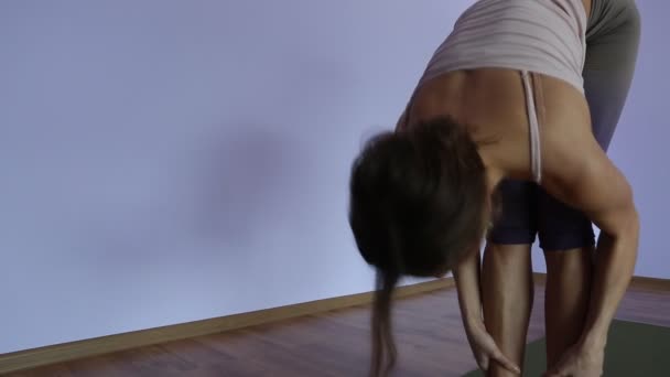Fiatal nő gyakorlatok jóga mozog, és pozíciók stúdió környezetben — Stock videók