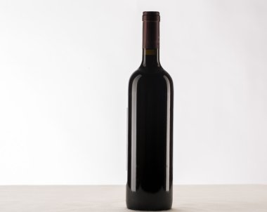 Kırmızı şarap ve beyaz arka planda izole edilmiş bir şişe.