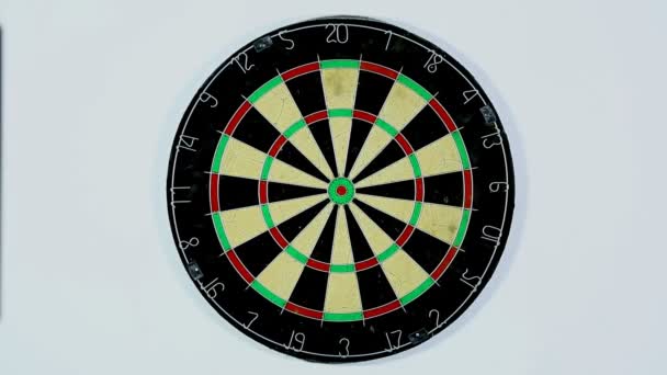 Een dart lijkt de bulls-eye van een dartbord. Brede shot van een dartboard van onderaf, Darten drie met een schot in de roos. — Stockvideo