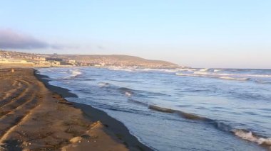 Bakü north shore Beach'te Hazar Denizi çökmesini dalga. Gün batımında kum plajındaki dalgalar. Güneş tropikal okyanus kıyısında akşam saat ışık..