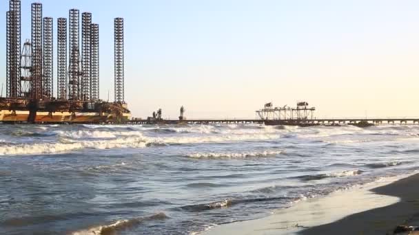 Ondas de praia com plataforma de petróleo no oceano. Mar Cáspio plataforma de perfuração de plataformas de petróleo offshore ao largo de Baku, Azerbaijão . — Vídeo de Stock