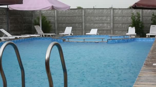 Lluvia fuerte cae en una piscina — Vídeos de Stock