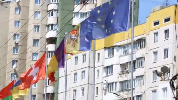 Nemzetközi zászlók több ország integetett a szél, az erkélyen egy épületet egy hivatalos találkozó. EU tagok zászlók lemondás Európai Parlament épülete előtt. — Stock videók