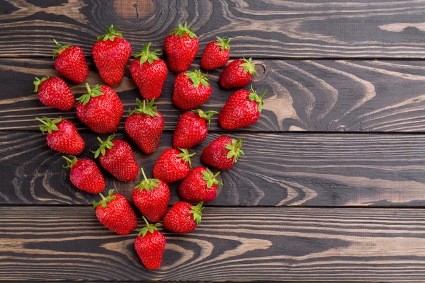 Frische Erdbeeren Array Herzform auf altem Holzhintergrund. lizenzfreie Stockfotos