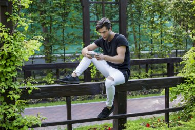 attractive young male model playing games on a smart-phone