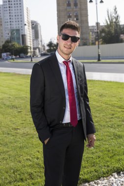 Bir takım elbise ve gözlük ve kırmızı kravat genç işadamı.